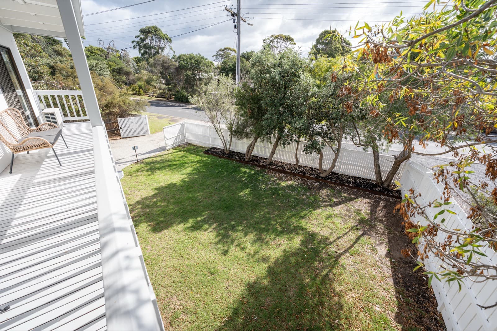Upper deck balcony overlooking garden and olive trees at Big Isle Retreat, Cowes